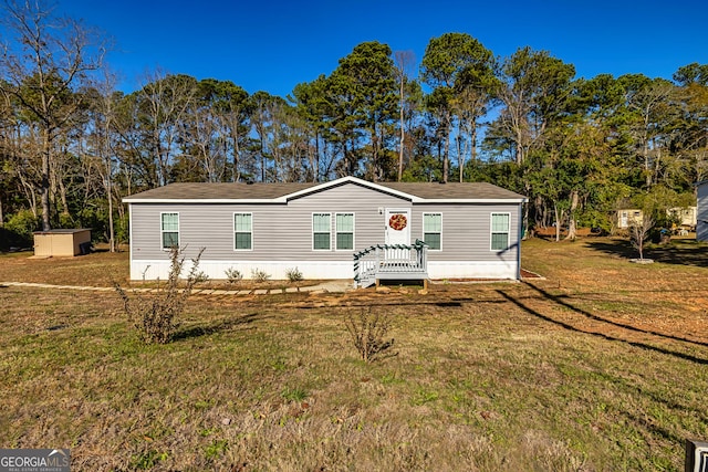 manufactured / mobile home featuring a front yard and a storage shed