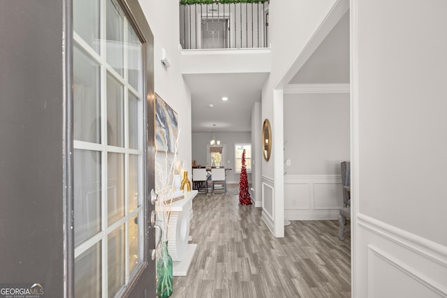 entryway with wood-type flooring and an inviting chandelier