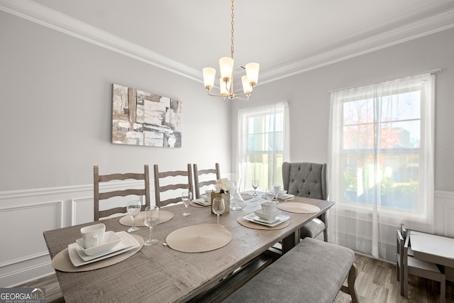 dining room featuring an inviting chandelier, crown molding, and hardwood / wood-style flooring