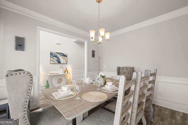 dining space with a notable chandelier, dark wood-type flooring, and ornamental molding