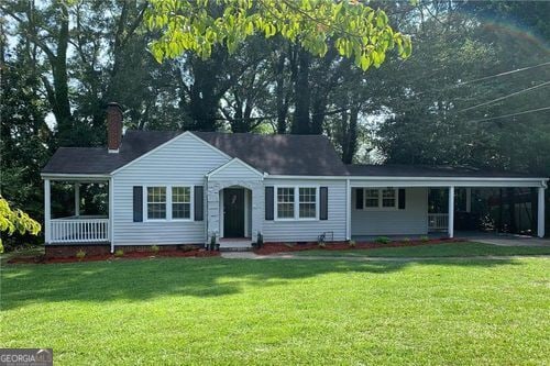 ranch-style home featuring a carport and a front yard