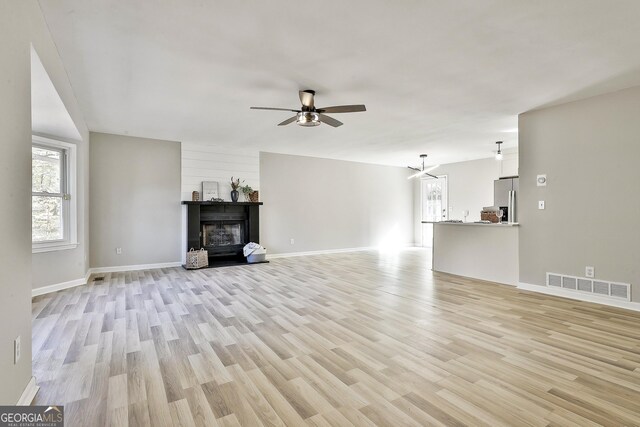 unfurnished living room with ceiling fan and light hardwood / wood-style flooring