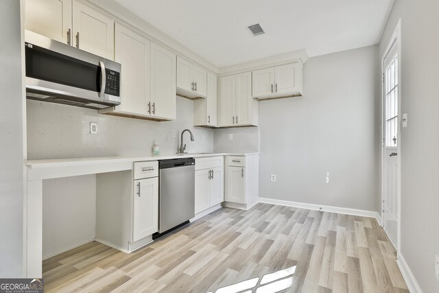 kitchen featuring white cabinets, stainless steel appliances, light hardwood / wood-style flooring, and sink