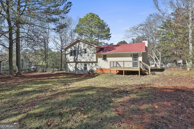 rear view of property with a lawn and a wooden deck