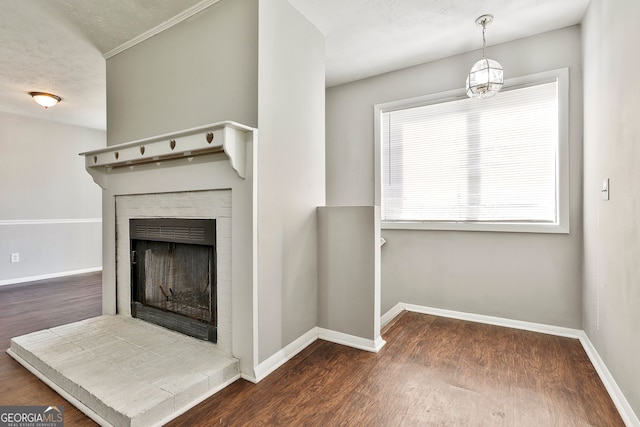 unfurnished living room featuring a textured ceiling, dark hardwood / wood-style flooring, and a tiled fireplace