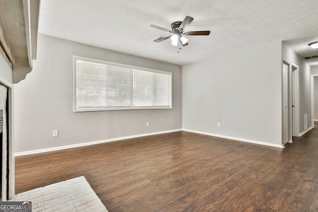 unfurnished living room featuring ceiling fan, dark hardwood / wood-style flooring, and a textured ceiling