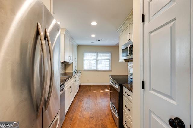 kitchen featuring appliances with stainless steel finishes, white cabinetry, and dark wood-type flooring