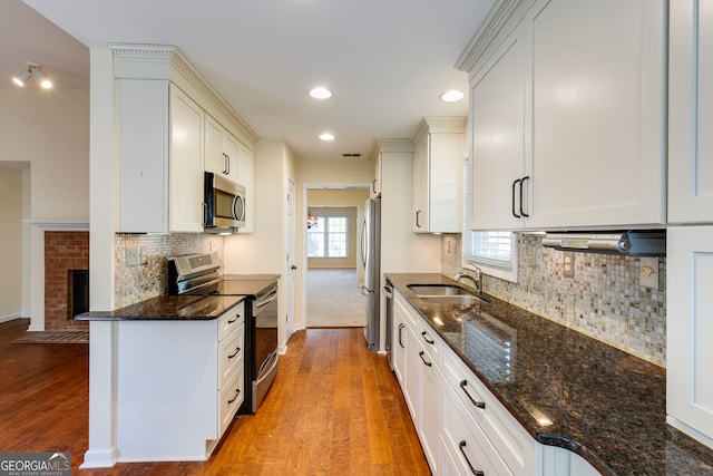 kitchen featuring plenty of natural light, light hardwood / wood-style floors, sink, and appliances with stainless steel finishes