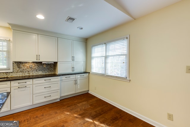 kitchen featuring backsplash, white cabinets, dark stone countertops, and dark wood-type flooring