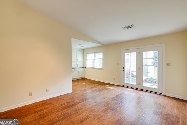 entryway with light hardwood / wood-style flooring and vaulted ceiling