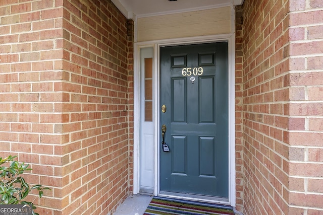 entrance to property featuring brick siding
