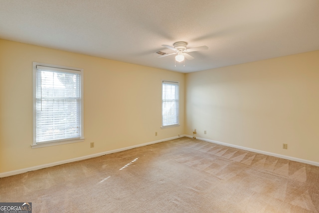 carpeted spare room featuring ceiling fan