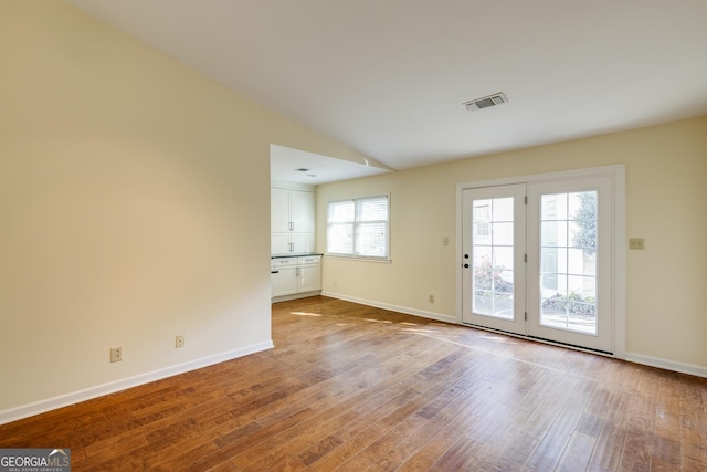interior space with baseboards, visible vents, and wood finished floors