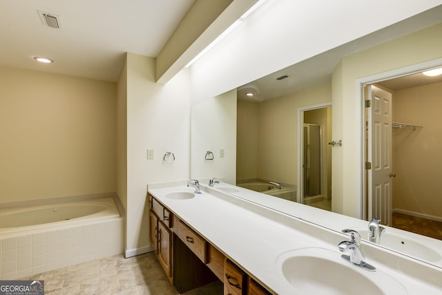 bathroom featuring visible vents, a sink, a garden tub, and a stall shower