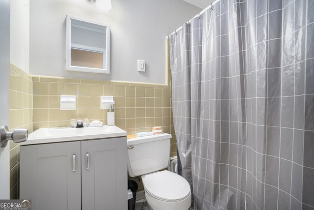 bathroom featuring a shower with shower curtain, toilet, and tile walls