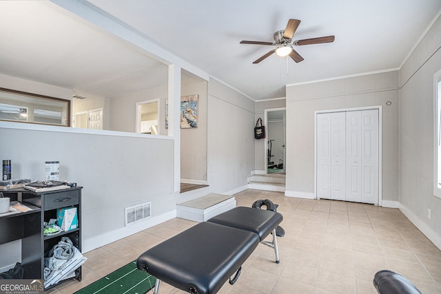 exercise area with light tile patterned floors, ceiling fan, and crown molding