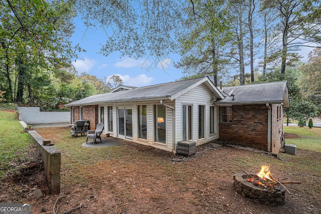 back of property with central AC and a fire pit