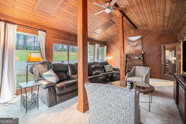 carpeted living room featuring vaulted ceiling, ceiling fan, wooden ceiling, and wood walls