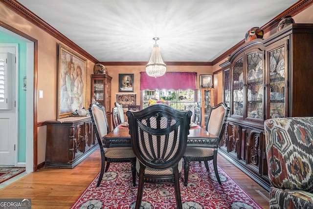 dining room with light hardwood / wood-style floors, crown molding, a wealth of natural light, and a chandelier