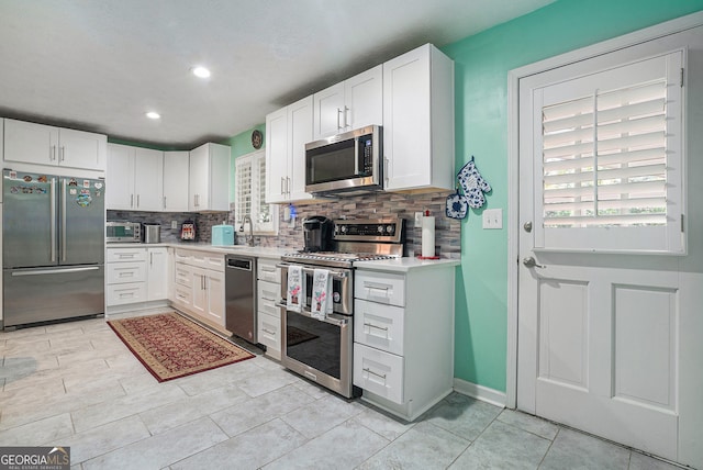 kitchen featuring white cabinets, stainless steel appliances, tasteful backsplash, and sink