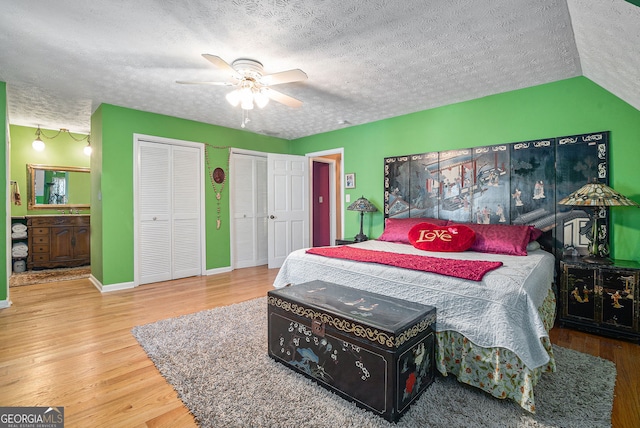 bedroom featuring hardwood / wood-style floors, a textured ceiling, vaulted ceiling, and ceiling fan