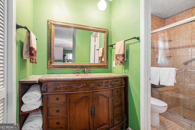 bathroom with tile patterned flooring, a textured ceiling, toilet, vanity, and a shower with shower door