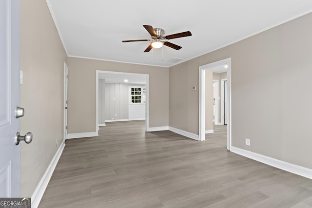 spare room featuring crown molding, ceiling fan, and light wood-type flooring