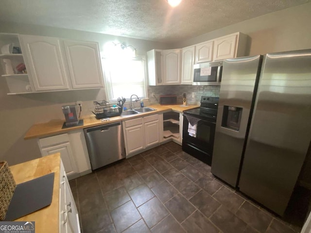 kitchen with white cabinets, sink, stainless steel appliances, and tasteful backsplash