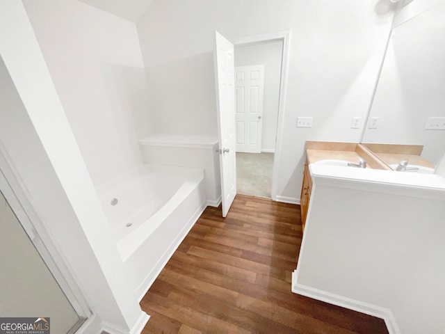 bathroom featuring a tub, vanity, and hardwood / wood-style flooring