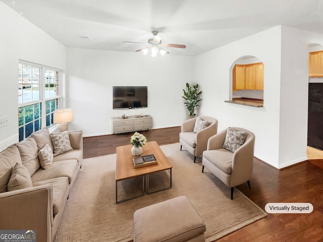 living room with ceiling fan, hardwood / wood-style floors, and vaulted ceiling