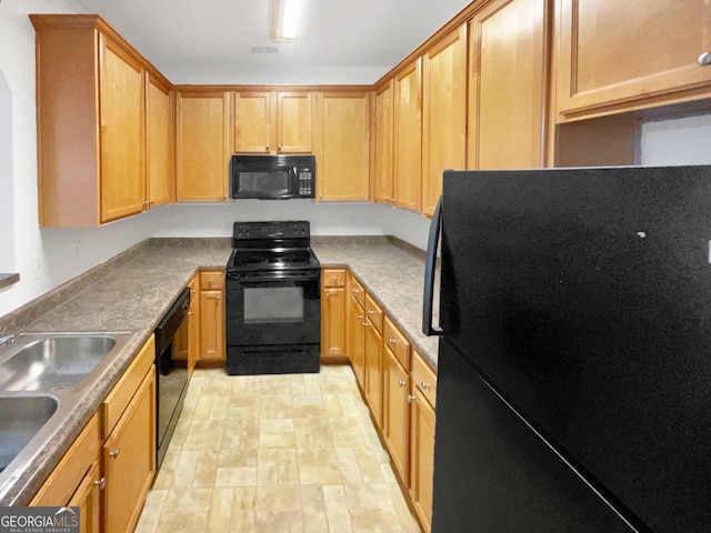 kitchen with sink, black appliances, and light hardwood / wood-style floors