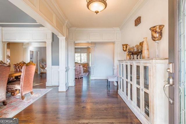 entryway with ornate columns, dark wood-type flooring, and ornamental molding