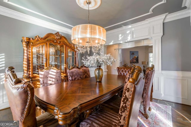 dining space with ornate columns, crown molding, and a chandelier