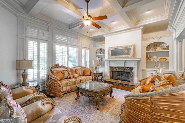 living room featuring hardwood / wood-style flooring, built in shelves, a premium fireplace, and crown molding