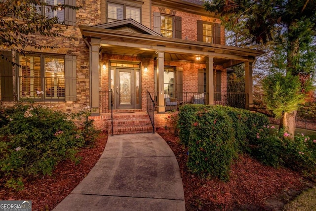 view of exterior entry featuring covered porch