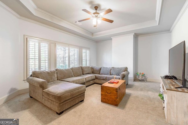 living room with light carpet, a tray ceiling, ceiling fan, and crown molding