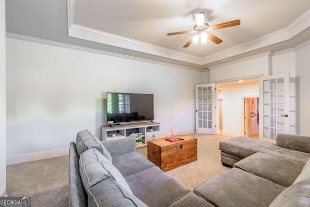 carpeted living room featuring a tray ceiling, ceiling fan, french doors, and ornamental molding