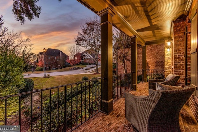 patio terrace at dusk featuring a porch