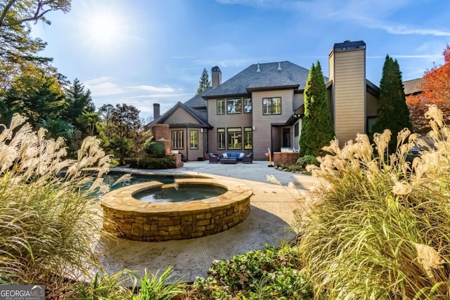 back of house featuring a patio area and an in ground hot tub