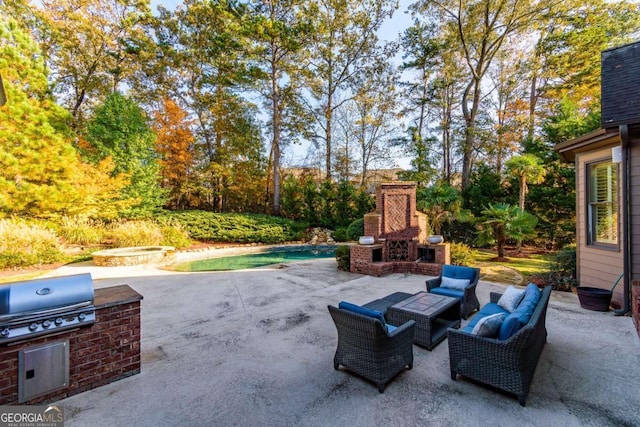 view of patio / terrace featuring an outdoor living space with a fireplace, a grill, and exterior kitchen