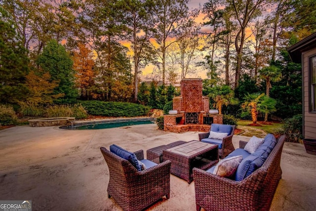 patio terrace at dusk featuring an outdoor brick fireplace