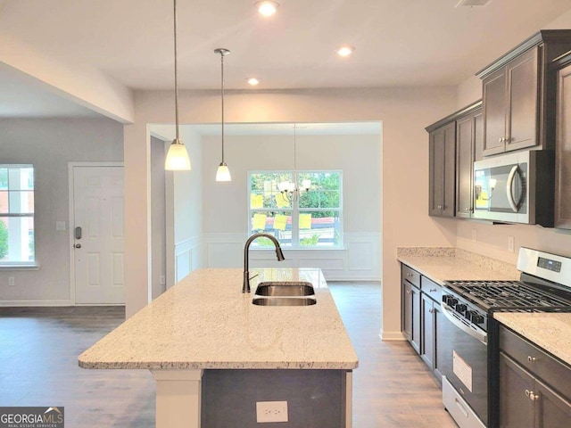 kitchen with hardwood / wood-style flooring, a wealth of natural light, sink, and appliances with stainless steel finishes