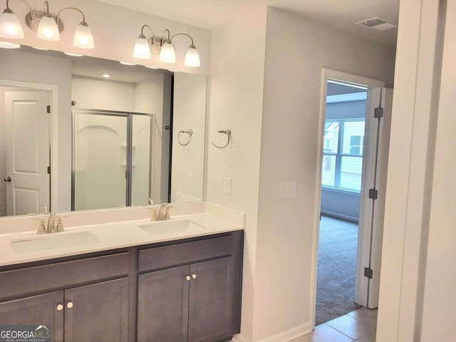 bathroom with tile patterned flooring, vanity, and an enclosed shower