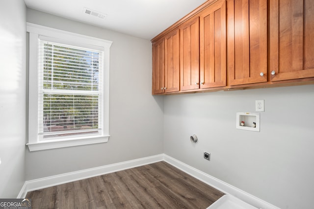 washroom featuring cabinets, hookup for a washing machine, dark hardwood / wood-style flooring, and electric dryer hookup