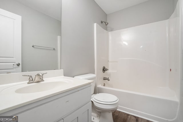 full bathroom featuring washtub / shower combination, wood-type flooring, vanity, and toilet