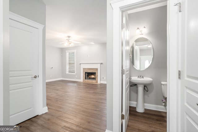 bathroom with a high end fireplace, hardwood / wood-style floors, ceiling fan, and sink