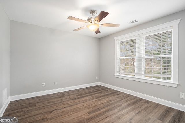 spare room with ceiling fan, plenty of natural light, and dark wood-type flooring