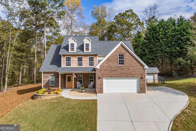 view of front of home with a garage, covered porch, and a front yard