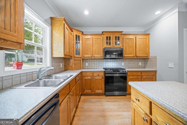 kitchen featuring dishwashing machine, range, sink, and a wealth of natural light