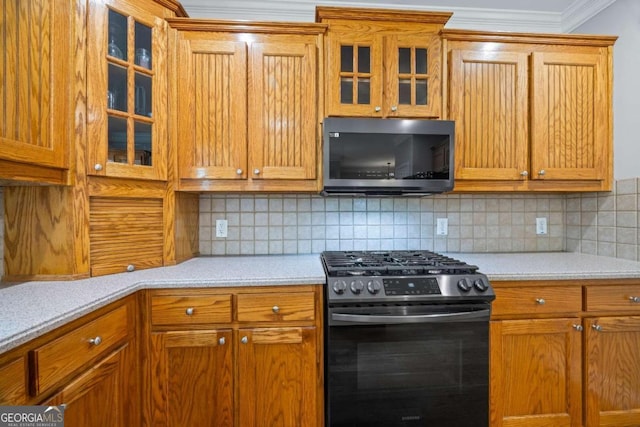 kitchen with backsplash, light stone countertops, ornamental molding, and stainless steel appliances